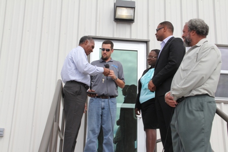 (l-r) Premier of Nevis and Minister responsible for Disaster Management Hon. Vance Amory receives the occupancy keys from Naval Facilities Engineering Command representative Mr. Tim Ryczek while members of Cabinet Hon. Hazel Brandy and Deputy Premier of Nevis Hon. Mark Brantley along with Director of the Nevis Disaster Management Department Mr. Lester Blackett look on